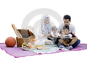 Muslim family reads a book in the picnic