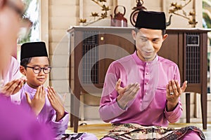 Muslim family saying prayers before meal