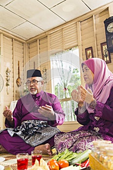 Muslim family saying prayers before meals