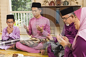 Muslim family saying prayers before meals