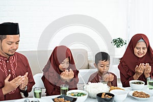 Muslim family pray when breaking fast
