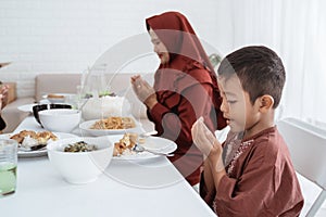 Muslim family pray when breaking fast