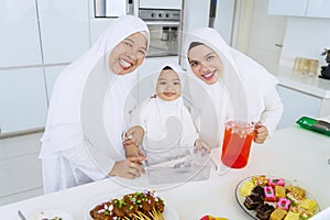 Muslim family smiling at camera together in kitchen