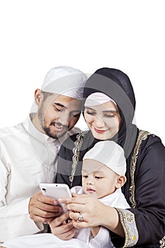 Muslim family and their son using a cellphone