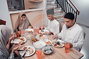 Muslim family together pray before meals