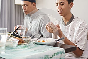 Muslim family together pray before meals