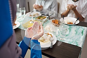 Muslim family together pray before meals