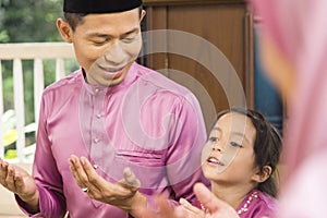 Muslim family saying prayers before meals