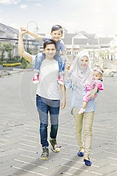 Muslim family walking on residential road