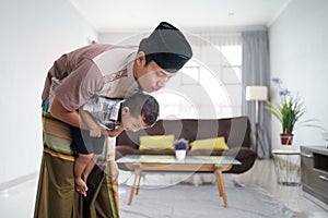 muslim father praying at home while babysit his son