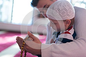 Muslim father and son praying together. Muslim dad and son praying in the mosque