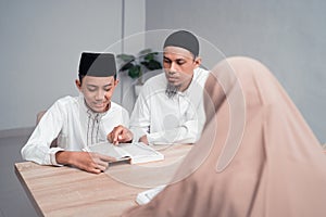 Muslim father teaching his son how to read quran