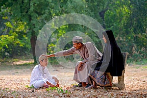 Muslim father touch son head with love emotion and stay with his family in the garden