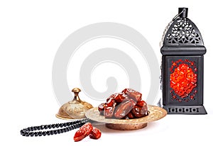 The Muslim feast of the holy month of Ramadan Kareem. Beautiful background with a shining lantern Fanus and dried dates on white.