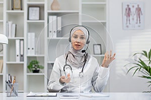 Muslim female doctor consulting online with headset