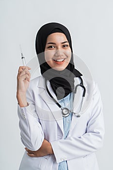 Muslim female doctor holding a syringe