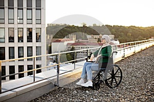 Muslim female with mobility issues daydreaming on terrace