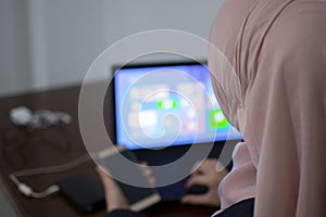 Muslim female student using laptop and mobile phone