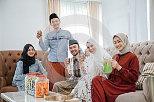 Muslim friends smiling while celebrating Idul Fitri by drinking
