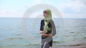 Muslim girl having jog training on pebble beach