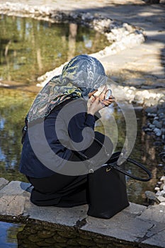 Muslim girl putting makeup in the park