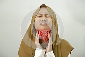 Muslim girl touching her neck feels pain in her sore throat, hard to swallow due to tonsillitis or thyroid gland problem