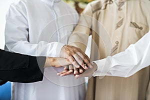 Muslim group of friends stacking hands photo