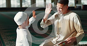 Muslim, high five in a mosque and a father with his son to study the quran for faith, belief or religion together