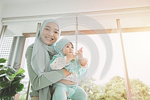 Muslim Hijab holding support her child baby happy smiling at home. mother care healthy infant looking camera