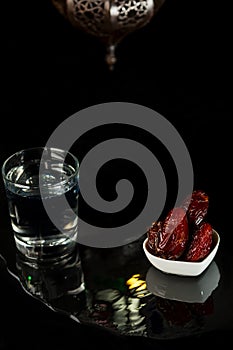 Muslim holiday of the Holy month of Ramadan Karim. Beautiful dates, a glass of clear water and a Fanus lantern