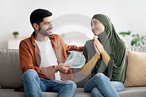 Muslim Husband Giving Money To Thankful Wife Sitting At Home