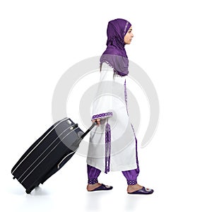 Muslim immigrant woman wearing a hijab walking carrying a suitcase photo