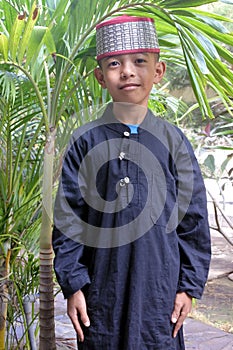 Muslim Indonesian boy dressed in traditional clouting looking at camera