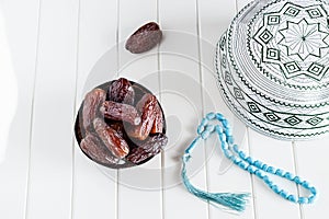 Muslim islamic faith concept taqiyah skullcap, blue rosary and dates medjul.