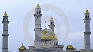 A Muslim Islamic mosque with golden minarets and a crescent moon against the sky.A religious temple for praying and worshipping th
