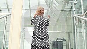 Muslim joyful business woman dancing for joy at work.