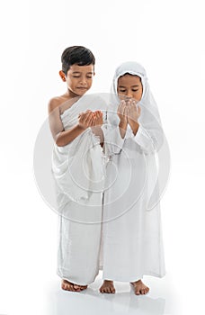 Muslim kid praying and wearing ihram