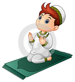 Muslim kid sitting on the prayer rug while praying
