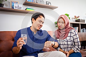 Muslim Malay couple in their home waiting for adzan maghrib