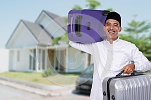 Muslim male carrying suitcase for eid mubarak celebration