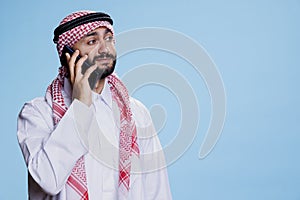 Muslim man answering smartphone call