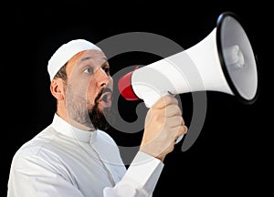 Muslim man with beard shouting through megaphone calling for Hajj