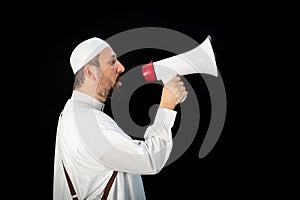 Muslim man with beard shouting through megaphone calling for Hajj