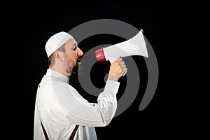 Muslim man with beard shouting through megaphone calling for Hajj