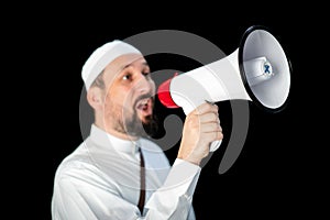 Muslim man with beard shouting through megaphone calling for Hajj