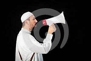 Muslim man with beard shouting through megaphone calling for Hajj