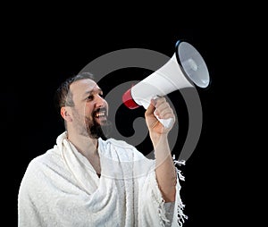 Muslim man with beard shouting through megaphone calling for Hajj