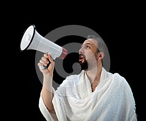 Muslim man with beard shouting through megaphone calling for Hajj