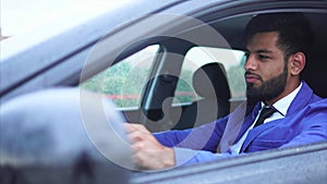 Muslim man in blue suit driving the car. Handsome serious businessman