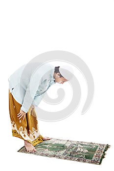 Muslim man bowing on prayer mat